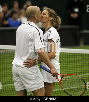 Die ehemalige Wimbledon-Meisterin Steffi Graf küsst ihren Mann und Partner Andre Agassi (links) am Ende eines Ausstellungsspiels gegen die Briten Tim Henman und Kim Clijsters auf dem Mittelplatz, während der Centre Court Celebration im All England Lawn Tennis and Croquet Club, Wimbledon, London. Stockfoto