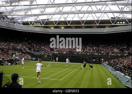 Die ehemalige Wimbledon-Meisterin Steffi Graf (vorne) im Einsatz mit ihrem Partner und Ehemann Andre Agassi im Einsatz gegen den Briten Tim Henman und Kim Clijsters auf dem Mittelplatz, während der Centre Court-Messe im All England Lawn Tennis and Croquet Club, Wimbledon, London. Stockfoto