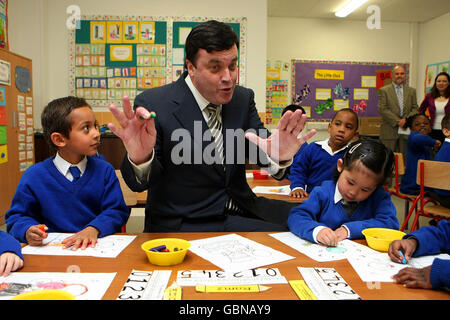 (Von links nach rechts) Abdul Hashem, 5, und Dalgeai Bosco, 5, zeichnen Bilder für den Finanzminister Brian Lenihan, als er die Scoi Caloilm Community National School in Porterstown, Dublin, offiziell eröffnet. Stockfoto