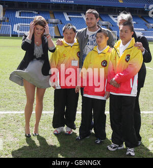 Prinzessin Eugenie, die bei einem Besuch im Chelsea Football Club, Stamford Bridge, Fulham, links war, wo sie Sir David Tang traf, rechts, Der Vorsitzende der Hong Kong Down Syndrome Association und Fußballspieler Frank Lampard, Centre und Mitglieder der Fußballmannschaft der Hong Kong Down Syndrome Association, als Sir David einen Austauschbesuch in Großbritannien durch das Team arrangiert hatte. Stockfoto