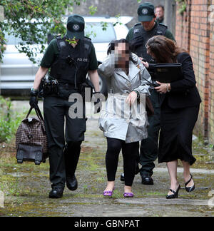 Eine Frau, Zentrum, wird von der Polizei weggeführt, nachdem sie ein Haus an der Lisburn Road im Süden von Belfast während einer Operation zur Rettung einer Reihe von Frauen in Belfast im Zusammenhang mit Menschenhandel überfallen hat. Stockfoto