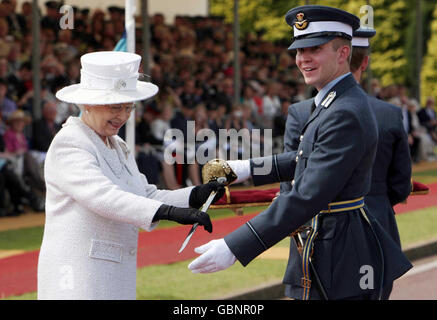 Queen Elizabeth II überreicht dem Offizier Cadet Chris Shone während seiner Abschlussfeier im RAF College Cranwell Lincolnshire das Ehrenschwert. Stockfoto