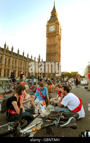 Eine Gruppe von Radfahrern sitzt auf der Westminster Bridge und macht ein Picknick, da sie während des Protestes gegen den Klimawandel im Zentrum Londons Verkehrschaos in die Gegend bringen. Stockfoto