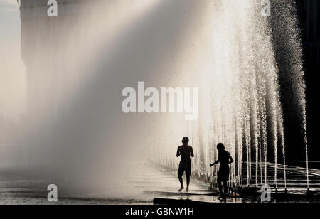 Kinder kühlen sich bei heißem Wetter in Almaty, Kasachstan, in Springbrunnen ab. Stockfoto