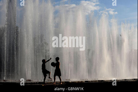 Kinder kühlen sich bei heißem Wetter in Almaty, Kasachstan, in Springbrunnen ab. Stockfoto