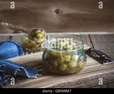 Hausgemachte Bio-Beeren Marmelade, Stachelbeere Gelee in Glas auf rustikalen Holztisch Stockfoto