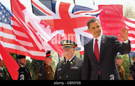 US-Präsident Barack Obama winkt, während er mit dem amerikanischen Friedhofsleiter der Normandie, Daniel Neese (links), bei einem Gedenkgottesdienst auf dem amerikanischen Friedhof der Normandie in Colleville-sur-Mer, Frankreich, zum 65. Jahrestag der Landungen des D-Day, spaziert. Stockfoto