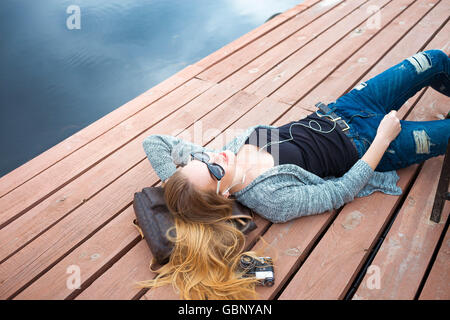 Entspannen Sie sich auf Pier junge Frau Stockfoto