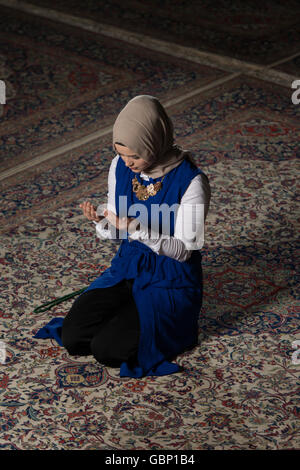 Junge muslimische Frau ist In der Moschee beten. Stockfoto