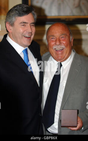 Jimmy Greaves (rechts) lächelt, nachdem er seine Medaille, die Premierminister Gordon Brown (links) für die Vertretung seines Landes bei der Weltmeisterschaft 1966 überreicht hatte, gesammelt hatte. Stockfoto