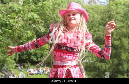 Eine Frau tanzt, während das West End Festival mit 'Scotland's Mardi Gras' beginnt, wo über tausend kostümierte Performer und Bands im Kelvingrove Park, Glasgow, paradierten. Stockfoto