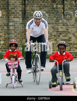 Sir Chris Hoy im Bild mit Rohanna (3) und Hamza (5) (rechts) starten eine landesweite Fahrradkampagne an der Northwold Primary School, London. Stockfoto