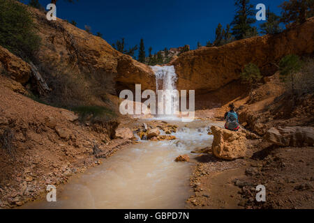 Backpacker Mädchen Exploring Bryce Canyon Wasserfall in der Nähe von Mossy Cave USA Reisen Landschaften Stockfoto