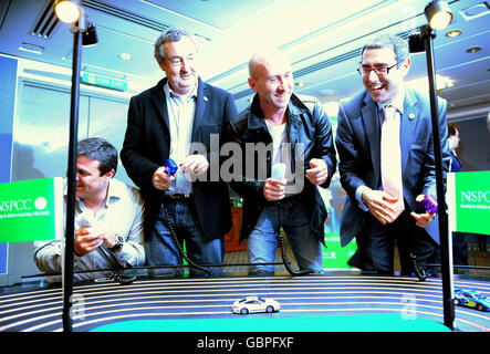 (Von links nach rechts) Mark Blundell, Nick Mason, Perry McCarthy (der ursprüngliche Top Gear Stig) und Michael Lucas von ING treten während des Child's Voice Appeal Circuit Launch in London auf einer Scalextric-Strecke gegeneinander an. Stockfoto