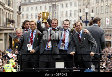 (L-R) die Engländer Jonny Wilkinson, Richard Hill, Mark Regan und Kyran Bracken zeigen den Webb Ellis Cup, während das Team auf einer offenen Bustour durch London geht, um den Sieg der Weltmeisterschaft zu feiern Stockfoto