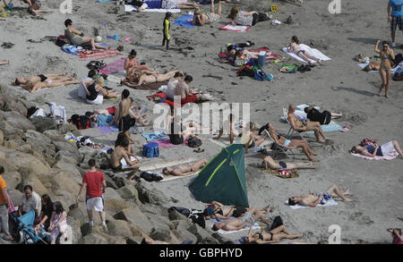 Die Zuschauer genießen die Sonne auf der Salthill Promenade, während sie das Pro-am-Küstenrennen am zweiten Wochenende des Volvo Ocean Race in Galway beobachten. Stockfoto