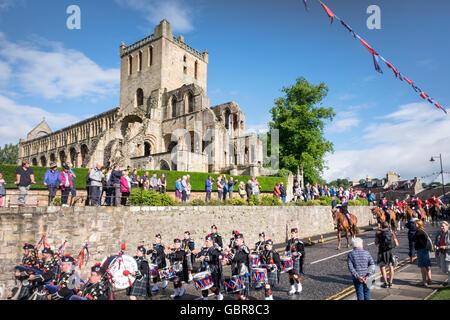 Jedburgh, UK. 8. Juli 2016.    Das Jethart Callant Festival, Festival Day The Jethart Callant Gary Hogg, nach hinten die Pipe Band und einem Kopf seiner angebrachten Anhänger im Schatten der Jedburgh Abbey, am 8. Juli 2016 in Jedburgh, Schottland. Bildnachweis: Rob Gray/Alamy Live-Nachrichten Stockfoto