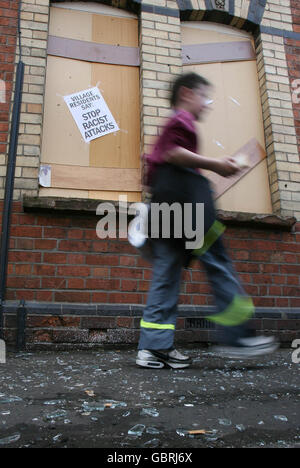 Rumänen aus Belfast gezwungen. Ein kleiner Junge geht an einem von rumänischen Flüchtlingen nach einem Angriff von Rassisten an diesem Wochenende freigewordenen Grundstück vorbei. Stockfoto