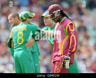 West Indies Kapitän Chris Gayle verlässt das Feld niedergeschlagen, nachdem er sein Wicket verloren hat, während die südafrikanischen Spieler beim ICC World Twenty20 Super Eights Spiel im Brit Oval, London, hinter sich feiern. Stockfoto