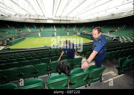 Ein schnifferer Hund patrouilliert auf dem Center Court im All England Lawn Tennis and Croquet Club, Wimbledon, London. Stockfoto