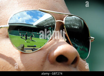 Sonnenbrillen spiegeln das Netz wider, das auf dem Center Court im All England Lawn Tennis and Croquet Club, Wimbledon, London, aufgelegt wird. Stockfoto