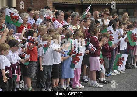 Kinder der Ysgol Rhys Pritchard Grundschule winken Fahnen, als sie die Ankunft der Königlichen Hoheit der Herzogin von Cornwall und des Prinzen von Wales im Llandovery Hospital, Dyfed, Wales erwarten. Stockfoto