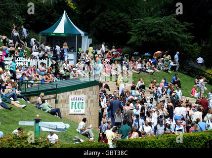 Fans entspannen sich in der Sonne während der Wimbledon Championships 2009 im All England Lawn Tennis und Croquet Club, Wimbledon, London. Stockfoto