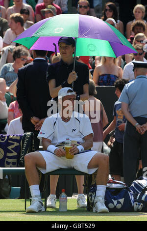 Der Australier Lleyton Hewitt lässt sich in einer Pause gegen Arengtinas Juan Martin Del Potro während der Wimbledon Championships 2009 beim All England Lawn Tennis and Croquet Club, Wimbledon, London, von der Sonne abschirmen. Stockfoto