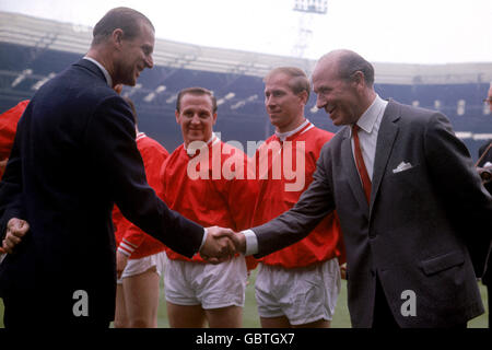 S.H. der Herzog von Edinburgh (l) schüttelt die Hände mit Manchester United-Manager Matt Busby (r) vor dem Spiel als United Maurice Setters (zweite l) und Bobby Charlton (zweite r) Schau mal Stockfoto