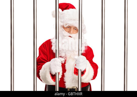 Reife Verbrecher in ein Weihnachtsmann-Kostüm stehen hinter Gittern in einem Gefängnis isoliert auf weißem Hintergrund Stockfoto