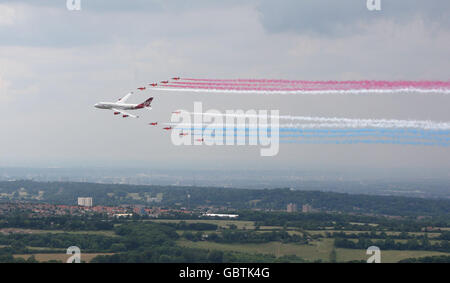 Das Royal Air Force Aerobatic Team "The Red Arrows" schließt sich einem Virgin Atlantic 747-400 Flugzeug namens "Birthday Girl" an, um an der Biggin Hill International Air Fair vorbei zu fliegen. Stockfoto