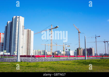 Block von Wohnungen im Bau, Krane arbeiten sind unter blauem Himmel im Sommertag Stockfoto