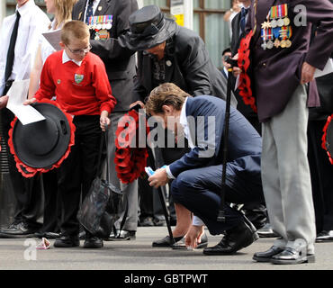 Der Comicschauspieler Eddie Izzard hilft Peggie Jefferson, 85, aus Grimsby, dessen Ehemann Roland, War Gründungsmitglied der Normandie Veterans Association und begleitete NVA-Mitglieder bei einer Kranzniederlegung im Cenotaph in Whitehall, im Zentrum von London, anlässlich des 65. Jahrestages der Landungen am D-Day des Zweiten Weltkriegs, in denen sie kämpften. Stockfoto