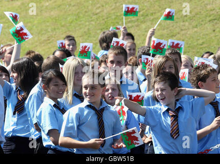 Kinder schwingen walisische Flaggen, während Prinz Charles, Prinz von Wales, eine Rede während eines Besuchs der Treorchy Comprehensive School hält. In Wales. Stockfoto