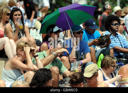 Fans auf dem Murray Mount schützen sich vor der Sonne während der Wimbledon Championships 2009 im All England Lawn Tennis and Croquet Club, Wimbledon, London. Stockfoto