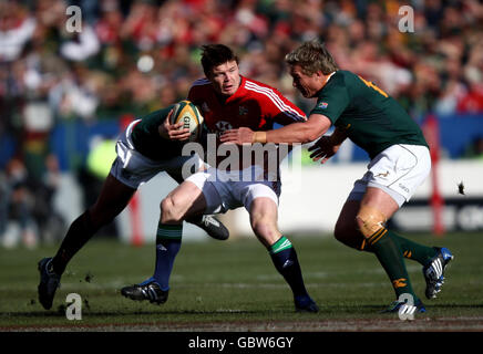 Britische und irische Löwen Brian O'Driscoll (Mitte) versucht beim zweiten Testspiel in Loftus Versfeld, Pretoria, Südafrika, ein Tackle von Jean de Villiers (links) und Adi Jacobs (rechts) aus Südafrika zu brechen. Stockfoto