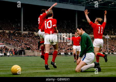 Leicester City-Torwart Gordon Banks blickt dejectedly nach unten, als David Herd (l) von Manchester United mit den Teamkollegen Denis Law (2. L), Johnny Giles (3. L) und Bobby Charlton (r) das zweite Tor seines Teams feiert Stockfoto