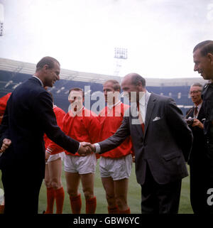 S.H. der Herzog von Edinburgh (l) schüttelt die Hände mit Manchester United-Manager Matt Busby (r) vor dem Spiel als United Maurice Setters (zweite l) und Bobby Charlton (zweite r) Schau mal Stockfoto