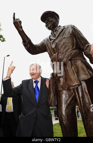 Der ehemalige Test-Cricket-Schiedsrichter Dickie Bird steht neben der Statue von sich selbst, enthüllt in seiner Heimatstadt Barnsley. Stockfoto