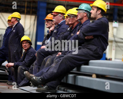 Arbeiter beobachten auf der BVT Surface Fleet Werft in Govan, Glasgow, wo die Prinzessin Royal am symbolischen „Schneiden von Stahl“ für den Rumpf des ersten der zwei neuen Flugzeugträger Großbritanniens teilnahm. Stockfoto