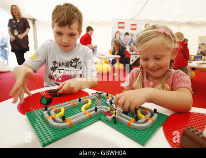L-R Billy Johnson 6 und Cacey Austin 5 spielen mit Race 3000 eines der LEGO Spiele, die im Legoland eingeführt wurden, mit 8 Spielen zu verschiedenen Preisen, die jeweils eine interaktive und fesselnde Kombination aus klassischen LEGO Elementen und einem einzigartigen LEGO Würfel bieten. Stockfoto