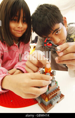 L-R Amal, 6 und Siraj Brepotra, 11, spielen mit Lava Dragon of the LEGO Games, die im LEGOLAND gestartet wurden, mit 8 Spielen zu verschiedenen Preispunkten, die jeweils eine interaktive und fesselnde Kombination aus klassischen LEGO Elementen und einem einzigartigen, baubaren LEGO Würfel bieten. Stockfoto