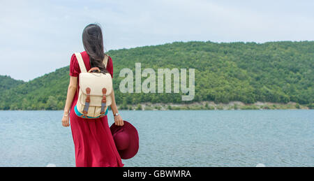 Modische Frau stand vor einem See allein Stockfoto