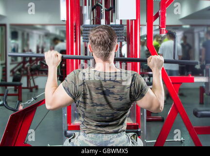 Muskulöser Mann Durchführung Lat Pulldown in der Turnhalle Stockfoto