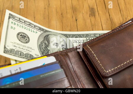 Leder-Portemonnaie mit Dollarnoten herausfallen Stockfoto