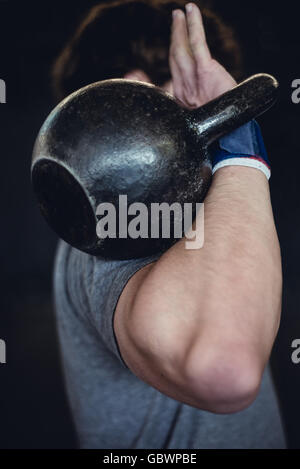 Mann im Fitnessraum mit kettlebell. Stockfoto