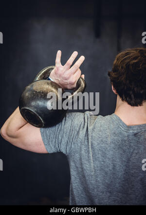 Mann im Fitnessraum mit kettlebell. Stockfoto