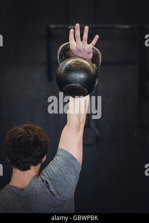 Mann im Fitnessraum mit kettlebell. Stockfoto