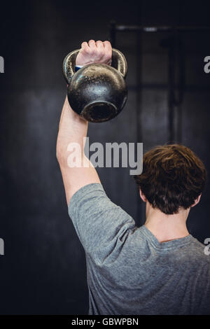 Mann im Fitnessraum mit kettlebell. Stockfoto