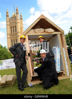 Grand Designs Moderator Kevin McCloud (links) mit dem Staatssekretär für Energie und Klimawandel Ed Miliband und Wohnungsminister John Healey (knieend), die sich am Bau einer isolierten Konstruktion in Victoria Tower Gardens, Westminster, London, beteiligt haben, um die Grand Designs Great British Refurb Campaign zu starten, Das fordert die Regierung auf, eine landesweite grüne Sanierung von Häusern zu starten, um Energie zu sparen und die CO2-Emissionen zu reduzieren. Stockfoto